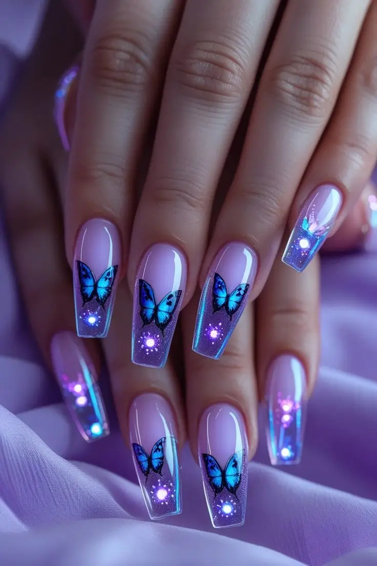 Close-up of a hand with long coffin nails featuring iridescent butterfly halo nail art with blue butterflies and a glowing holographic effect on a sheer purple base, showcasing a magical and trending USA nail design.