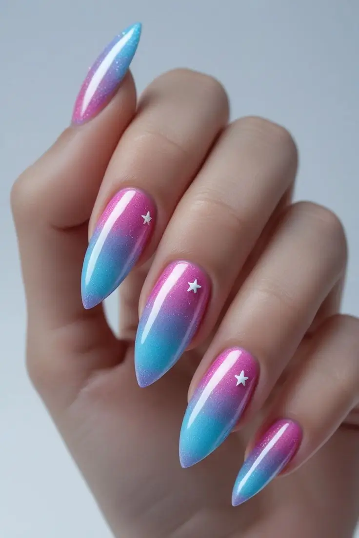 Close-up of a hand with long almond nails featuring aurora holographic fade nail art with a pink and blue gradient, accented by small white stars, showcasing an ethereal and trending design for US manicures.