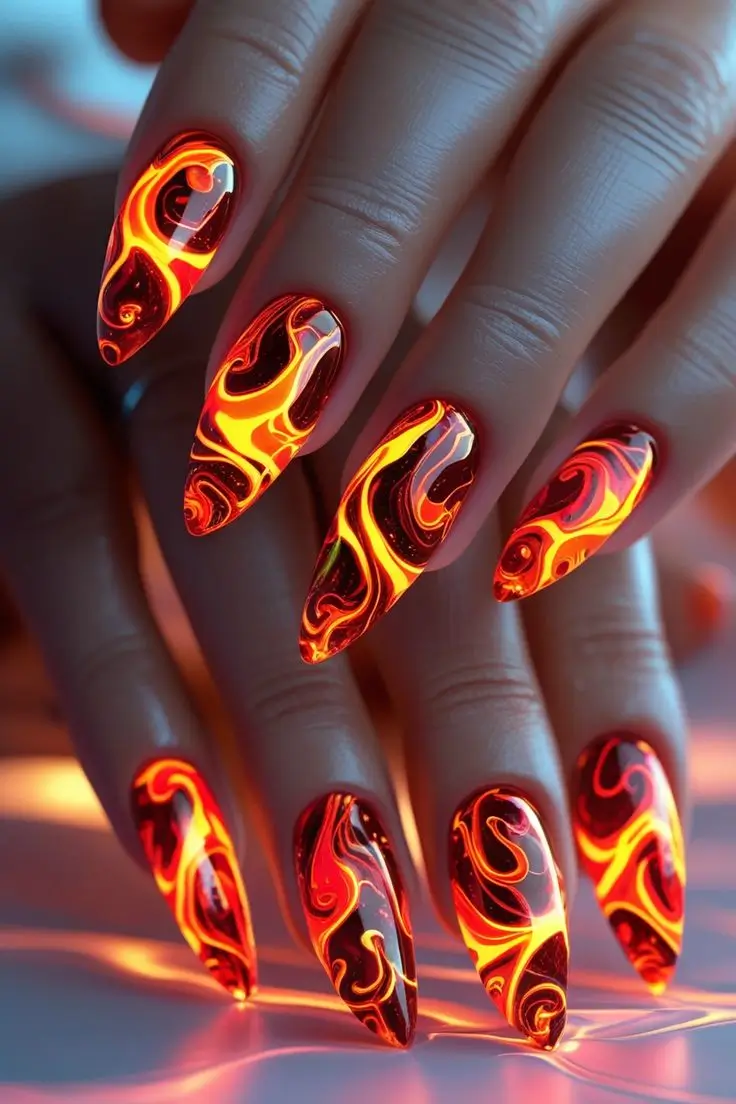 Close-up of a hand with long stiletto nails featuring neon lava swirl nail art with glowing orange and red flame patterns on a black base, showcasing a bold and fiery trend for US manicures.