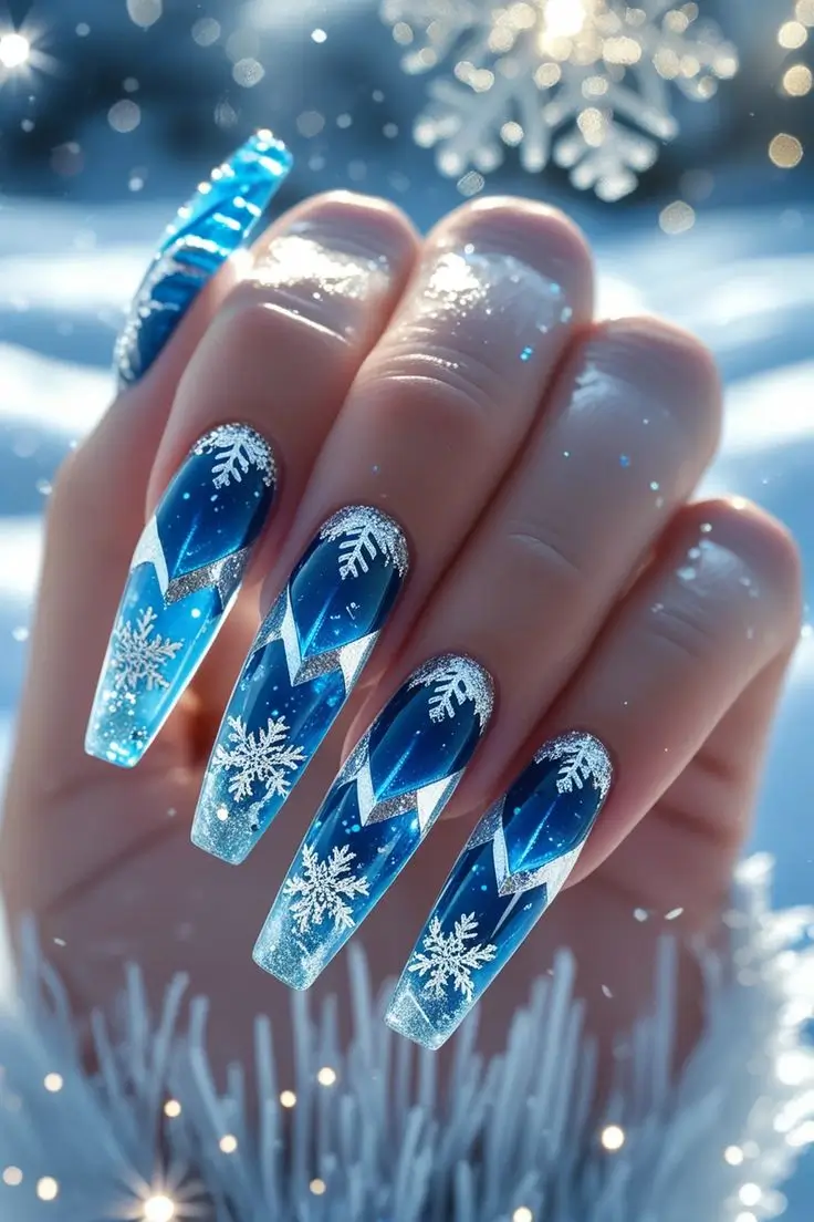Close-up of a hand with long coffin nails featuring frozen diamond cut nail art with an icy blue translucent base, silver glitter tips, and white snowflakes, showcasing a winter-inspired and trending design for US manicures.